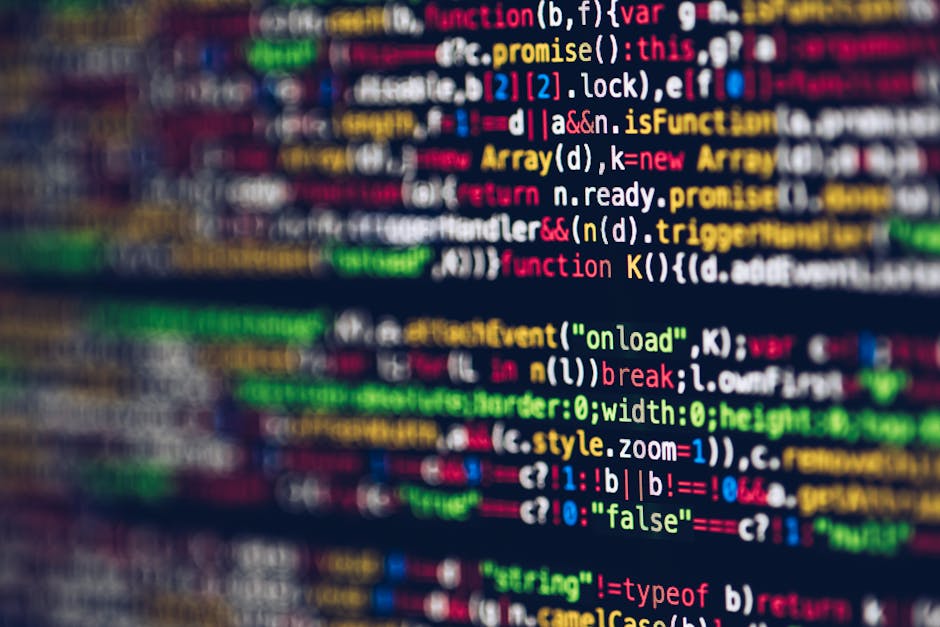 A close-up of a computer screen displaying lines of colorful programming code, predominantly featuring syntax highlighting in bright green, red, blue, yellow, and white against a dark background. The 